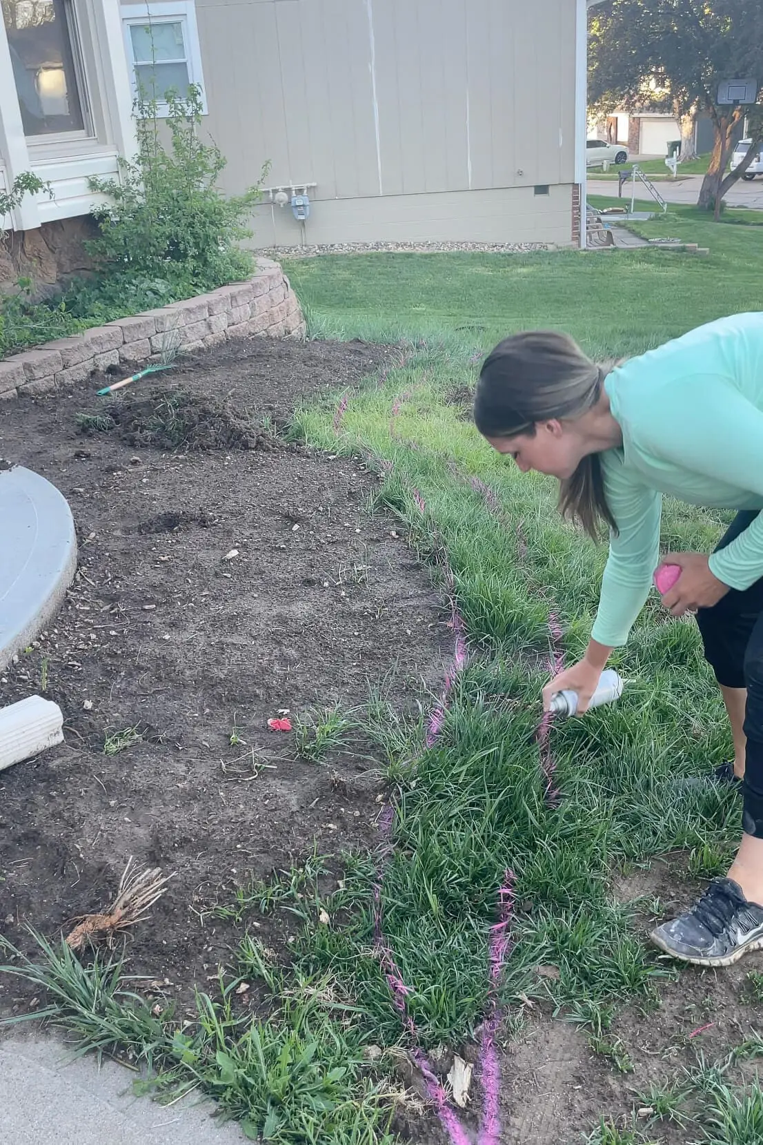 Using spray paint to mark where I want to add the concrete curb to my yard.